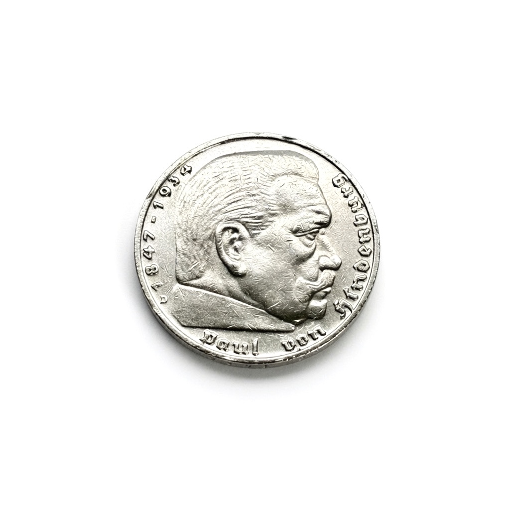 Close-up of a silver coin showing a man's profile facing right with engraved inscription around the edge.